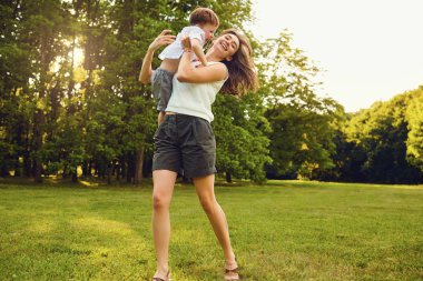Gün batımında Parkta oynayan çocuk ile anne.