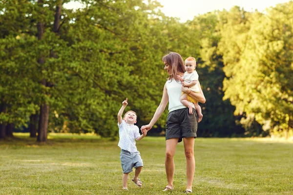 Mutter mit Kindern im Sommerpark. — Stockfoto