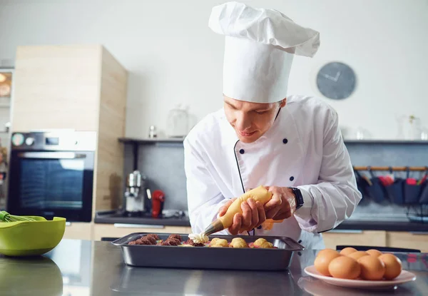 Un pasticcere prepara cupcake in cucina . — Foto Stock