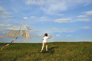 Çocuk çocuk bir uçurtma ile sahada çalışır..