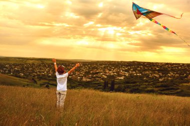 Çocuk çocuk bir uçurtma ile sahada çalışır..
