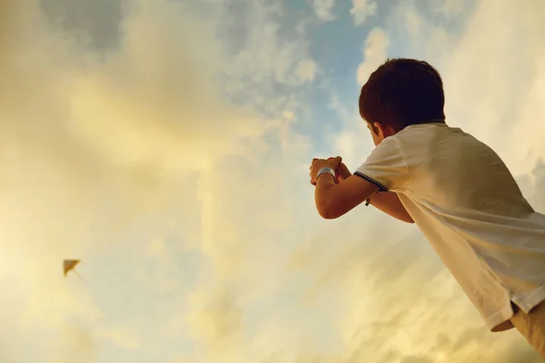 Gyermek fiú egy kite az égen a felhők. — Stock Fotó