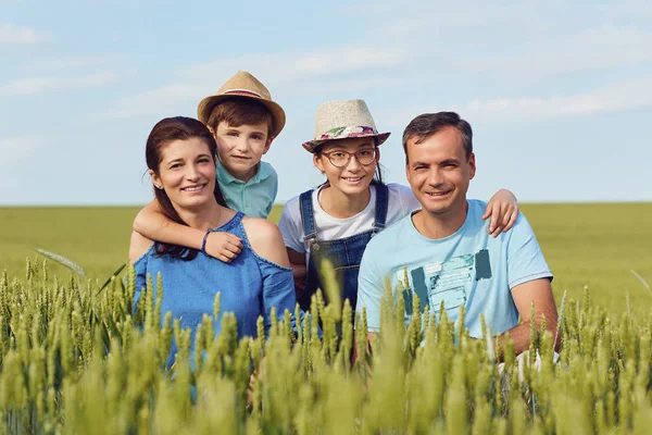 Doğa Çim üzerinde oturan mutlu bir aile portresi. — Stok fotoğraf