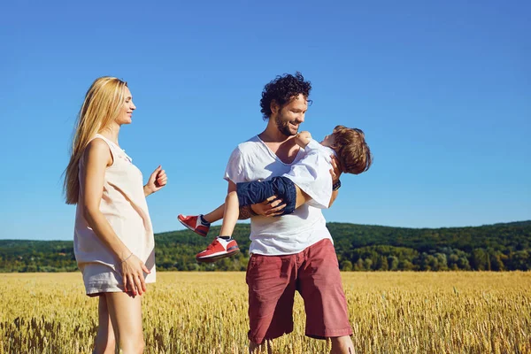 Una familia feliz está disfrutando la diversión con un niño al aire libre . — Foto de Stock