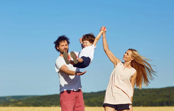 Une famille heureuse s'amuse avec un enfant à l'extérieur . — Photo