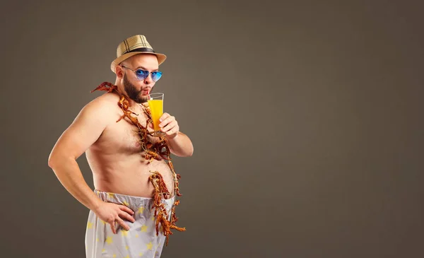 Hombre gordo divertido con un vaso de jugo en vacaciones . —  Fotos de Stock