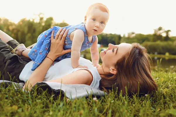 Matka i dziecko bawiące się na trawie w parku. — Zdjęcie stockowe