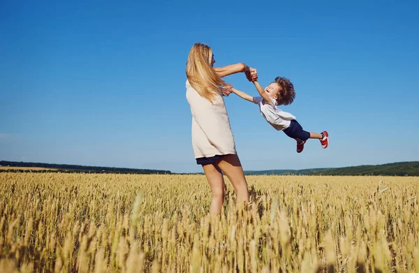 Eğlenceli yaz aylarında doğa üzerinde olan bir çocuğun annesi döner. — Stok fotoğraf