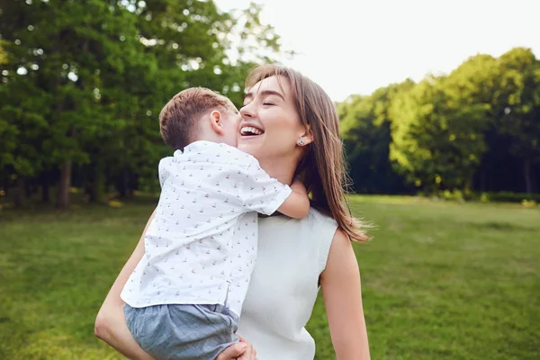 Anne ve oğlu parkta sarılıyorlar. 