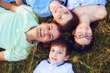 Mutlu bir aile portresi üstten görünüm doğada çimenlerin üzerinde