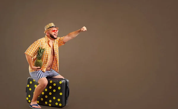 Un om gras amuzant de echitatie o valiză într-o vacanță de vară . — Fotografie, imagine de stoc