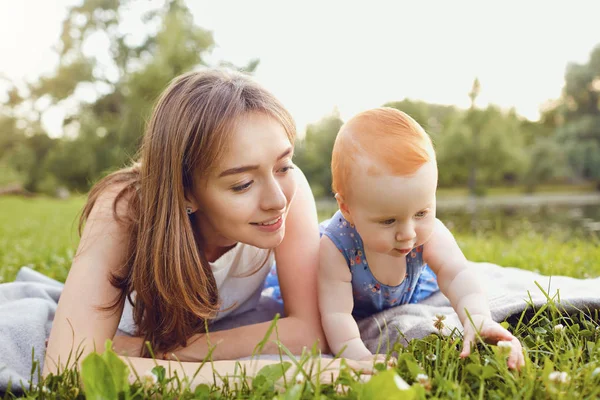 Anne ve bebek Park'ta çimenlerin üzerinde oynama.