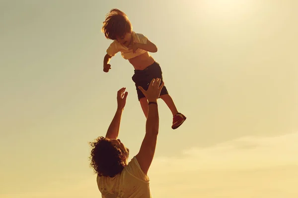 Ojciec i dziecko grając w przyrodzie o zachodzie słońca. — Zdjęcie stockowe