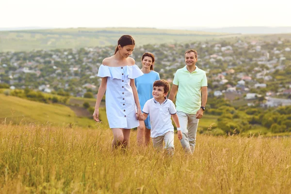 Família feliz está se divertindo ao redor do campo . — Fotografia de Stock