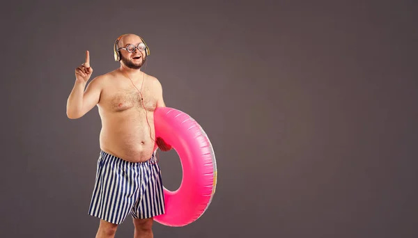 Grueso hombre divertido con una barba con un círculo para nadar . — Foto de Stock