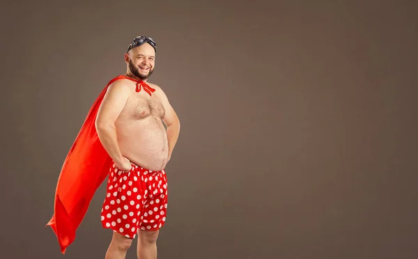 Funny fat man in a super hero costume. — Stock Photo, Image