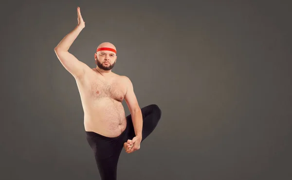 En skäggig man med en naken mage gör yoga. — Stockfoto