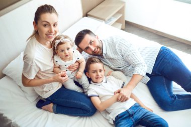 Mutlu aile yatak yatakta yatan oynarken.