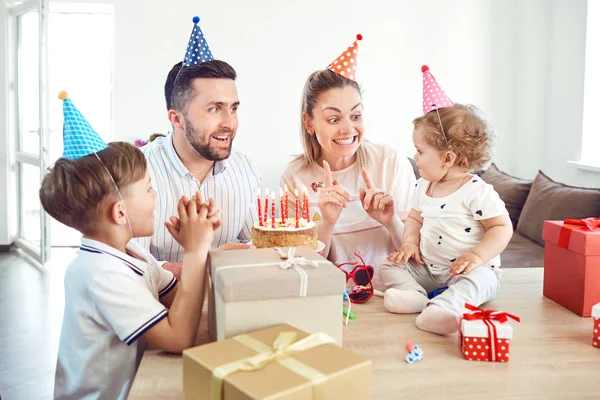 Una familia feliz con pastel celebra una fiesta de cumpleaños . — Foto de Stock