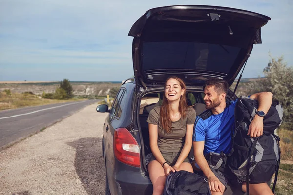 Quelques touristes avec des sacs à dos près d'une voiture sur la nature . — Photo