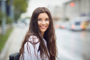 Genç esmer kız gülümsüyor şehrin sokak