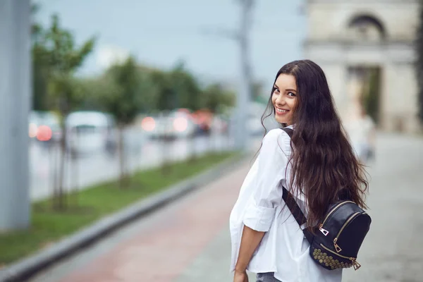 Fiatal barna lány mosolyog a város utca — Stock Fotó