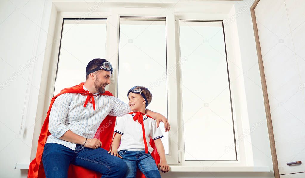 Father and son at the window in the room. 