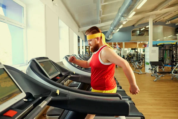 Um homem gordo engraçado fazendo exercícios no ginásio . — Fotografia de Stock