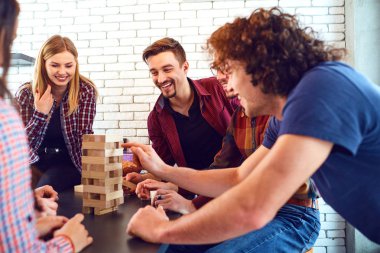 Neşeli bir grup genç insan masa oyunları oynamak.