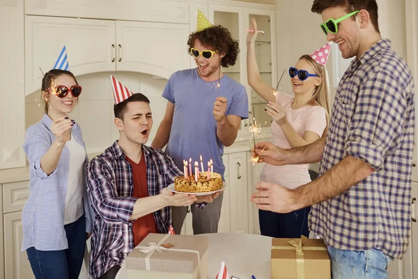 Amigos con pastel celebrando cumpleaños en una fiesta . — Foto de Stock