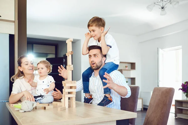 A family plays board games sitting at a table indoors.