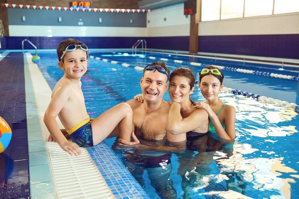 Een gelukkige familie lacht in een zwembad. — Stockfoto