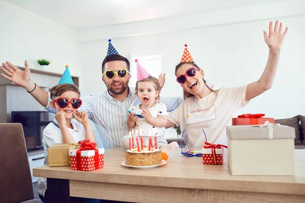 Una familia feliz con un pastel de velas celebra una fiesta de cumpleaños — Foto de Stock