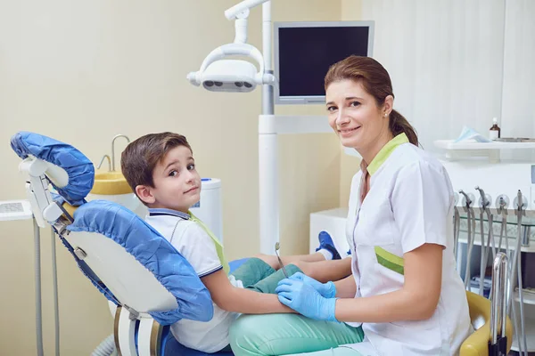 Uma criança com um dentista em um consultório odontológico . — Fotografia de Stock