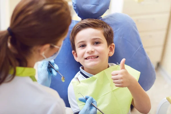 Ένα παιδί με έναν οδοντίατρο σε ένα οδοντιατρείο. — Φωτογραφία Αρχείου