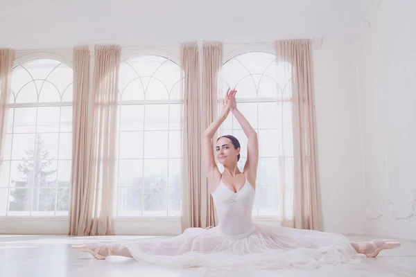 Uma bailarina em um cordel em roupas brancas em um estúdio branco . — Fotografia de Stock