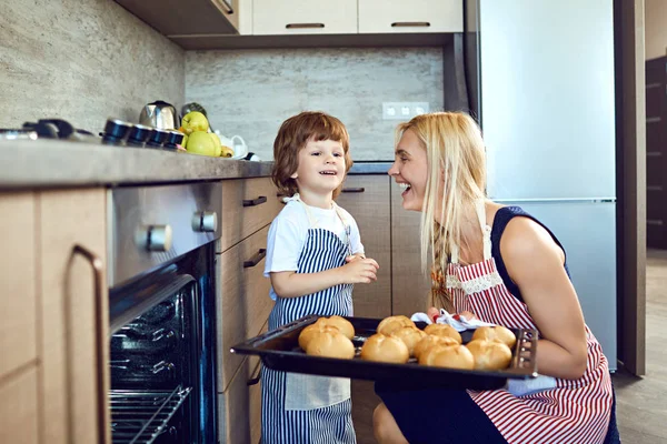 Ibu dan anak dengan nampan daun dari oven . — Stok Foto