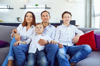 Mutlu aile odasında kanepede oturan gülümseyen.