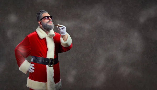 Papá Noel con un peinado de moda fuma un cigarro . — Foto de Stock