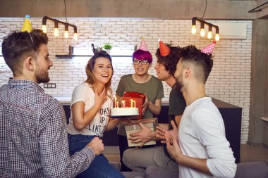 Arkadaş grubu doğum günü kutluyor mumlar ile pasta.