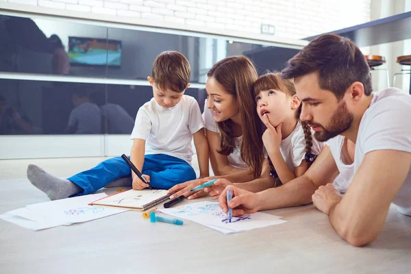 Uma família se baseia no papel deitado em seu tempo livre no chão . — Fotografia de Stock