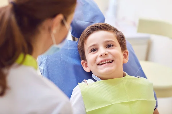 Uma criança com um dentista em um consultório odontológico . — Fotografia de Stock