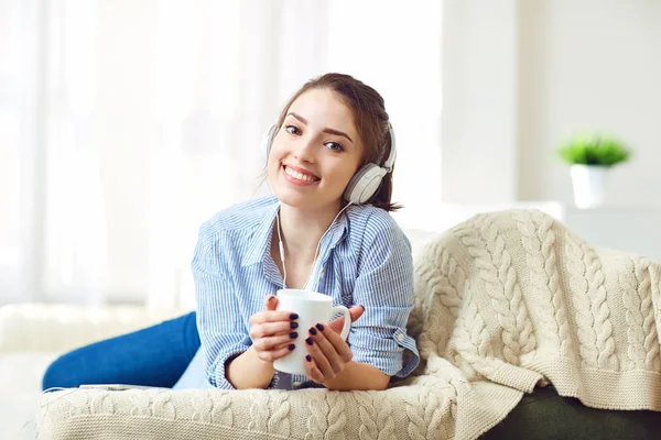 A lány a fejhallgatóban mosolyog zenét hallgat.. — Stock Fotó