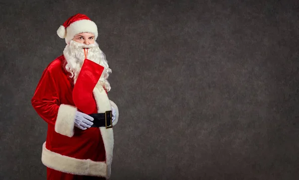 Glücklich lustig Weihnachtsmann mit roter Socke auf dem Hintergrund. — Stockfoto