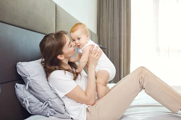 Madre jugando con el bebé en la cama . — Foto de Stock