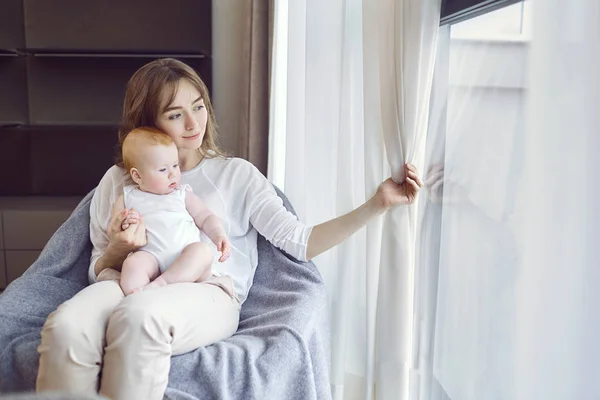 앞에 자에 앉아 그녀의 팔에 아기와 엄마 — 스톡 사진