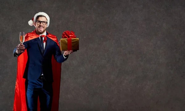 Empresário em um traje de Papai Noel, um super-herói com um copo o — Fotografia de Stock