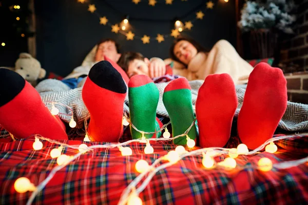 Kerst sokken op de voeten van een familie van Kerstmis. — Stockfoto