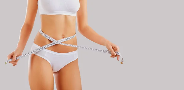 Corpo magro de uma mulher em lingerie com um centímetro . — Fotografia de Stock