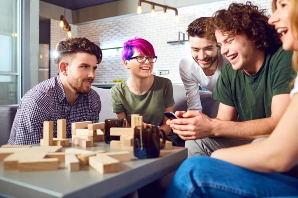 Eine fröhliche Gruppe von Freunden spielt Brettspiele. — Stockfoto